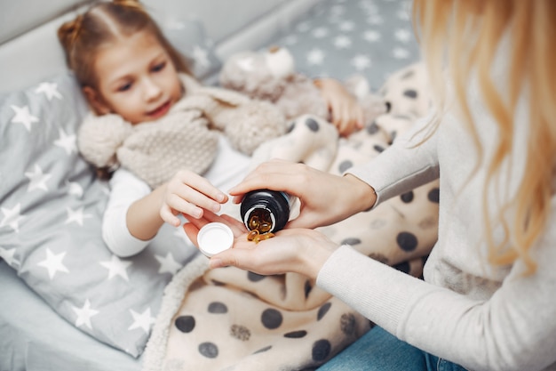 Mère avec sa fille illnes dans une chambre à coucher