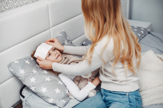 Mère avec sa fille illnes dans une chambre à coucher