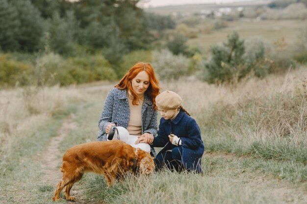 Mère et sa fille jouant avec un chien. Famille dans le parc de l'automne. Concept d'animal familier, animal domestique et mode de vie. Temps de l'automne.