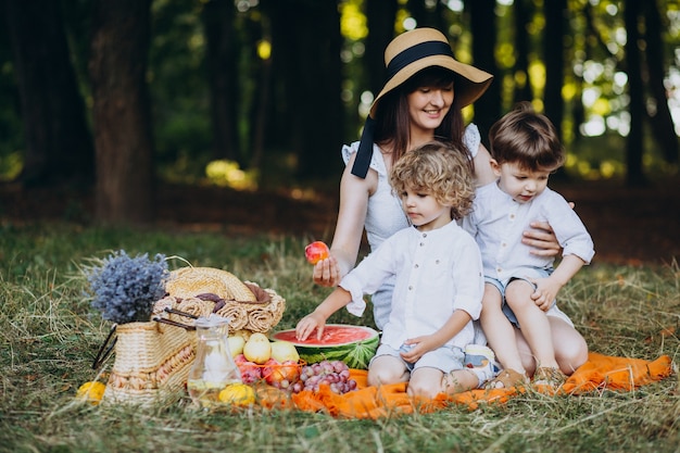 Mère avec ses fils ayant pique-nique en forêt