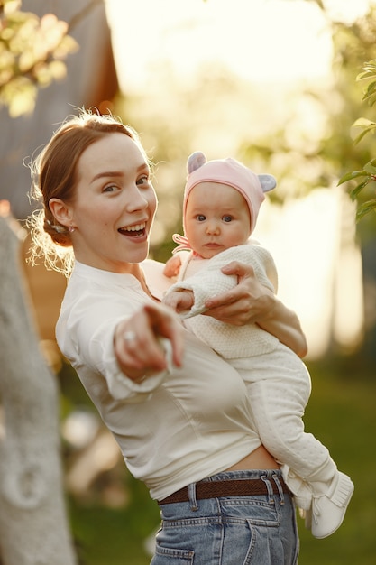 Mère avec son bébé passe du temps dans un jardin d'été