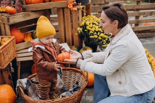 Mère avec son petit fils par les citrouilles à l'halloween