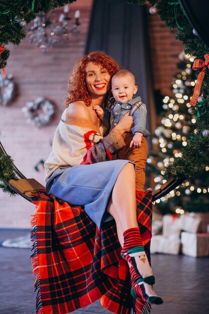 Mère avec son petit fils près du sapin de Noël