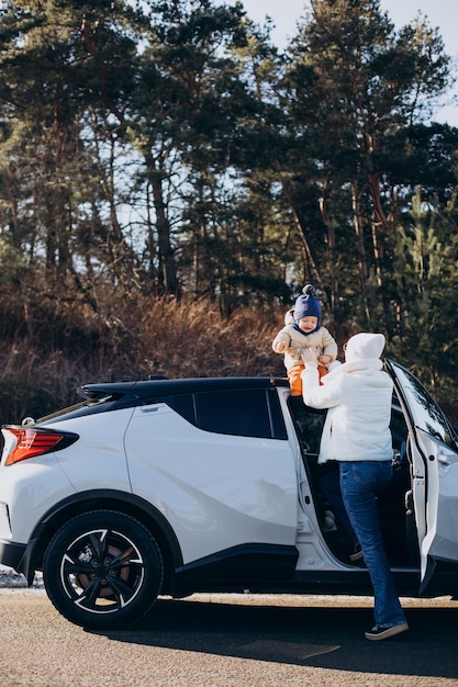 Mère avec son petit fils près de la voiture