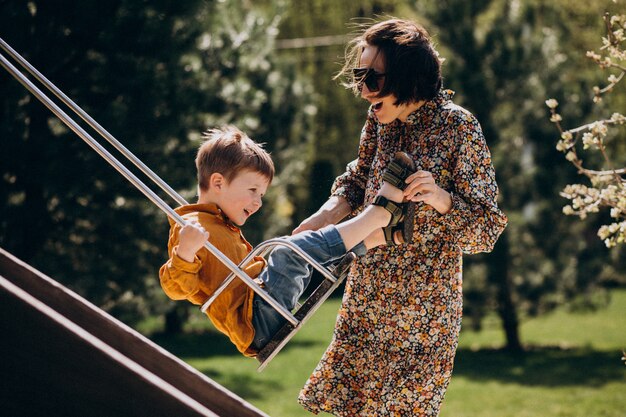 Mère avec son petit fils se balançant sur l'arrière-cour