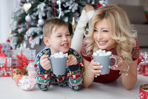 mère souriante et enfant à la maison dans des vêtements confortables