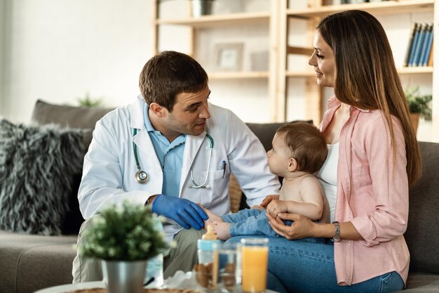 Mère souriante et son petit fils communiquant avec un médecin lors d'un examen médical