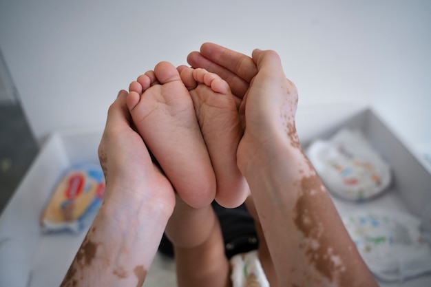 Photo gratuite mère tenant ses pieds d'enfant