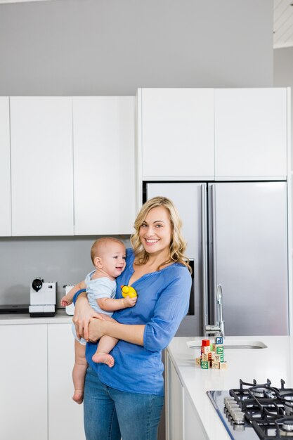 Mère tenant son bébé dans la cuisine