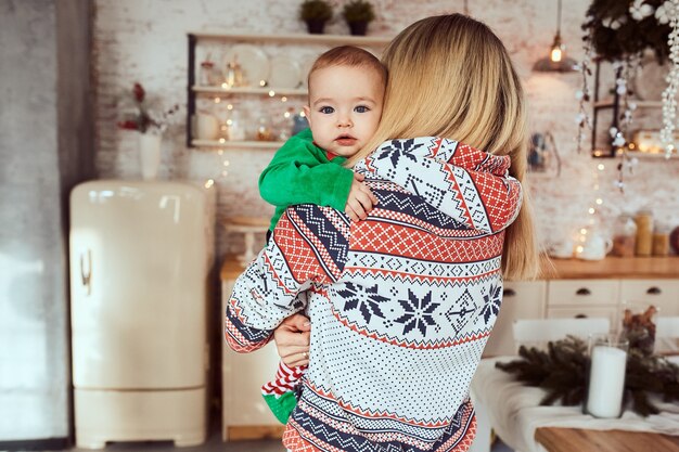 Mère tient son mignon petit fils sur les mains