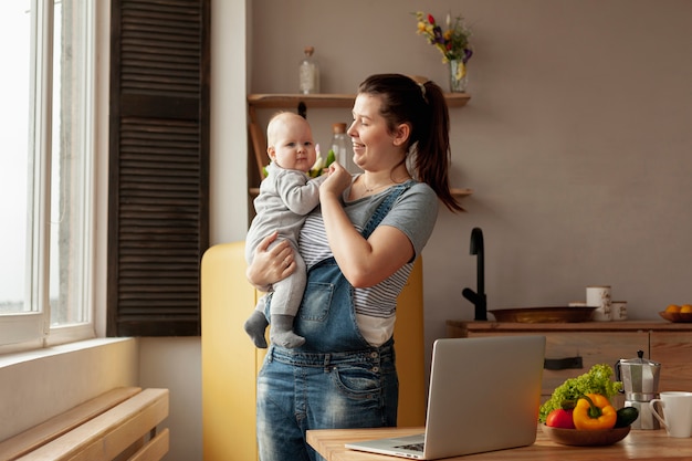 Mère vue de face avec bébé à la maison