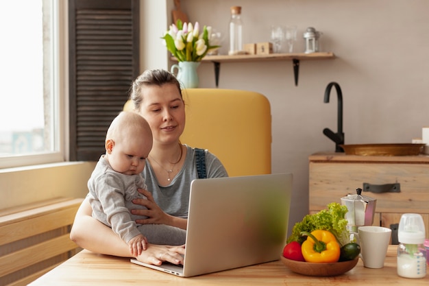 Photo gratuite mère vue de face avec bébé à la maison