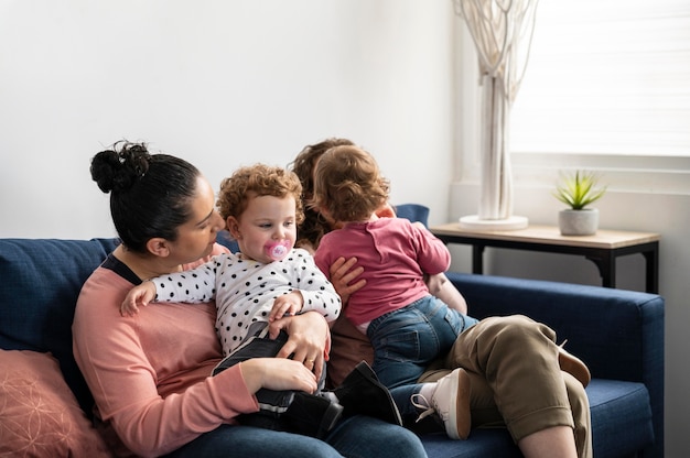 Mères LGBT à la maison sur le canapé avec des enfants