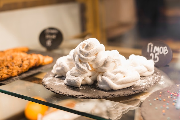 Meringue blanche et tordue sur une plaque d&#39;ardoise dans la vitrine