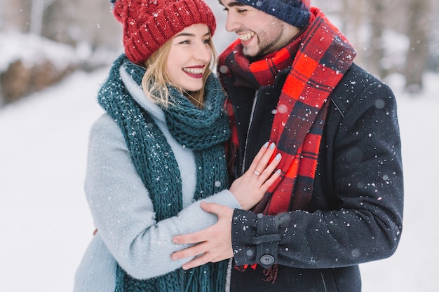 Merveilleux jeune couple dans les chutes de neige