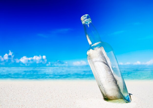 Message dans une bouteille sur la plage.