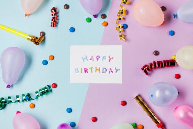 Message de joyeux anniversaire en bleu et rose entouré de banderoles; gemmes et ballons sur fond coloré