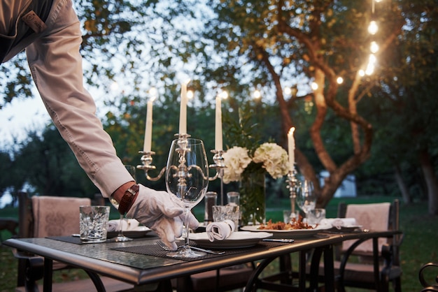 Photo gratuite met un verre. garçon main dans les gants. le travailleur est engagé à servir la table