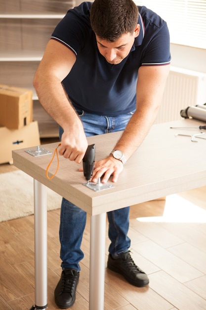 Photo gratuite meubles d'assemblage d'homme pour la nouvelle maison qu'ils ont achetée