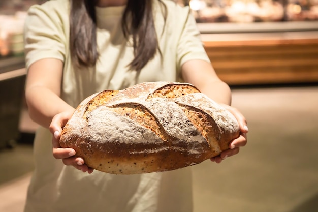 Photo gratuite miche de pain dans des mains féminines dans un supermarché