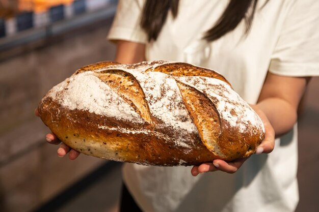 Photo gratuite miche de pain dans des mains féminines dans un supermarché