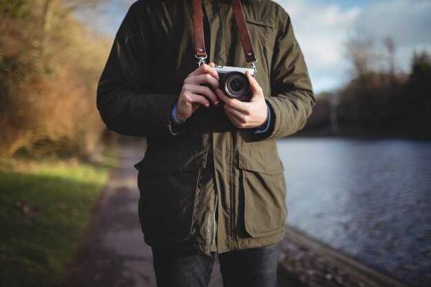 Mid-section of man holding camera