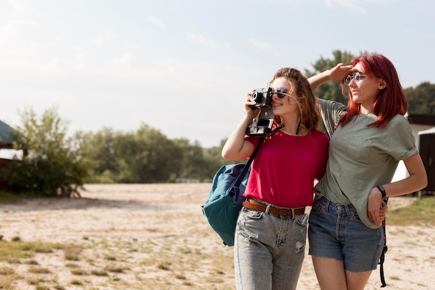 Photo gratuite mid shot femmes prenant des photos dans la nature