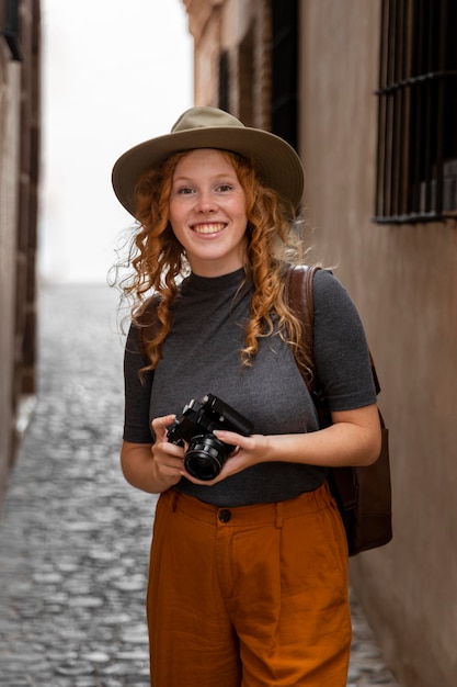 Photo gratuite mid shot girl avec chapeau et appareil photo