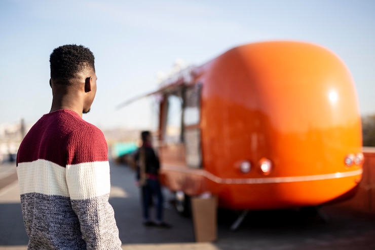 Photo gratuit mid shot male marchant vers food truck