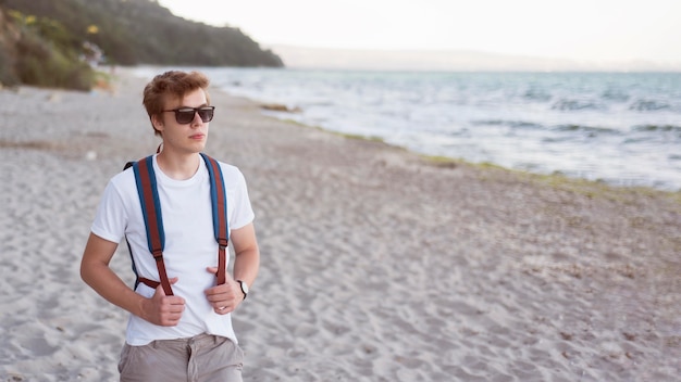 Photo gratuite mid shot teen avec sac à dos sur la plage