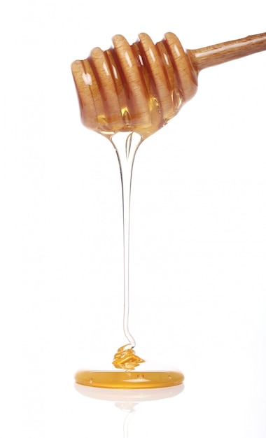 Miel dégoulinant d'une cuillère en bois