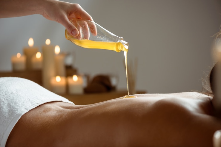 Photo gratuit miel verser sur le dos nu de la femme dans le salon spa.