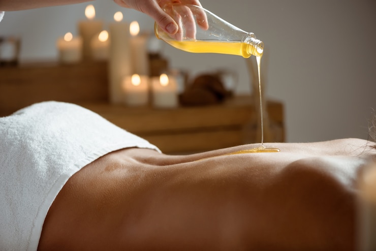 Photo gratuit miel verser sur le dos nu de la femme dans le salon spa.