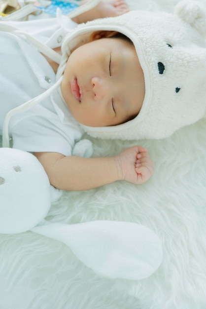 Mignon bébé garçon dormir avec un doux rêve et un lit moelleux blanc paisible