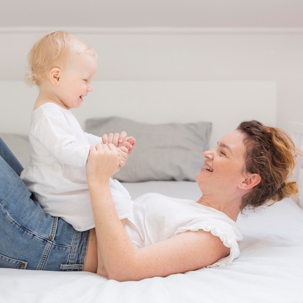 Photo gratuite mignon petit bébé jouant avec maman