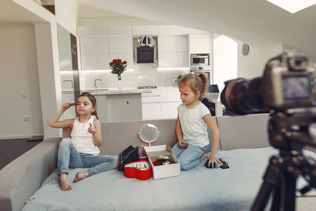 Mignon petit blogueur avec des cosmétiques d'enregistrement vidéo à la maison