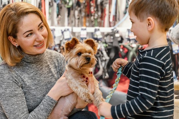 Mignon petit chien avec des propriétaires à l'animalerie