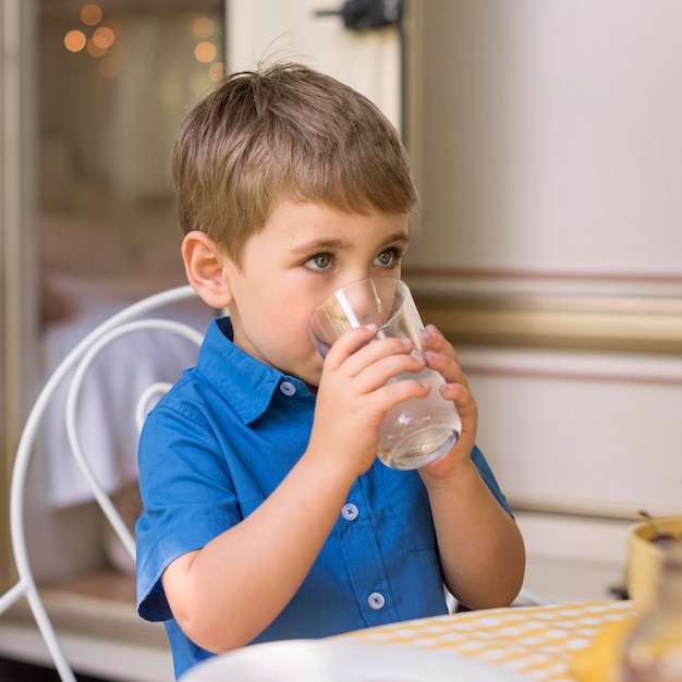 Photo gratuite mignon petit garçon buvant de la limonade