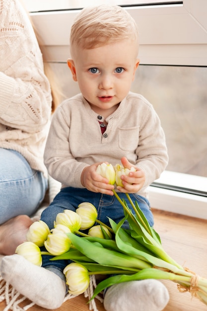 Mignon petit garçon avec des fleurs