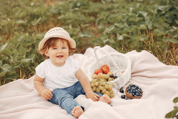 Mignonne petite assise sur une couverture dans un parc