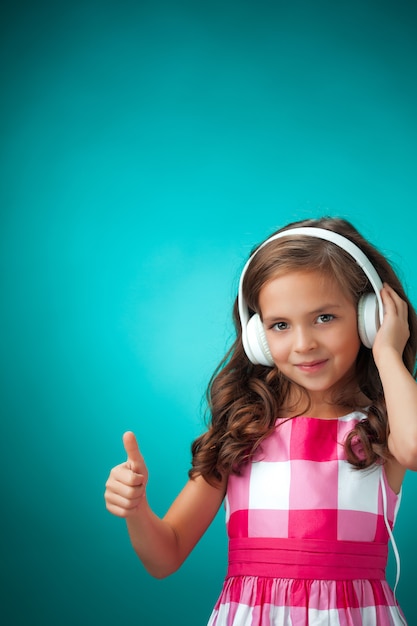 La mignonne petite fille joyeuse sur fond orange