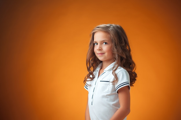 mignonne petite fille joyeuse sur orange