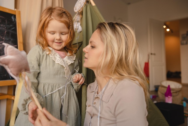 Mignonne petite fille à la peau claire aux cheveux rouges joue avec sa jeune mère à la maison Concept de passer du temps