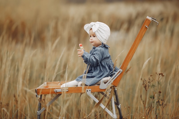 Mignonne petite fille peignant dans un champ d'automne