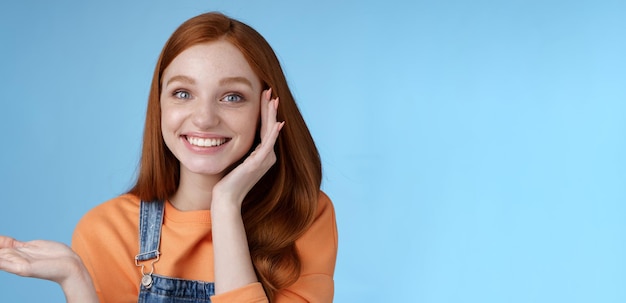 Mignonne tendre chatismatic happy smiling redhead girl présentant un produit impressionnant montrer l'objet palm hold h