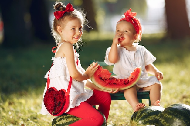 Mignons Petits Enfants Avec Des Pastèques Dans Un Parc