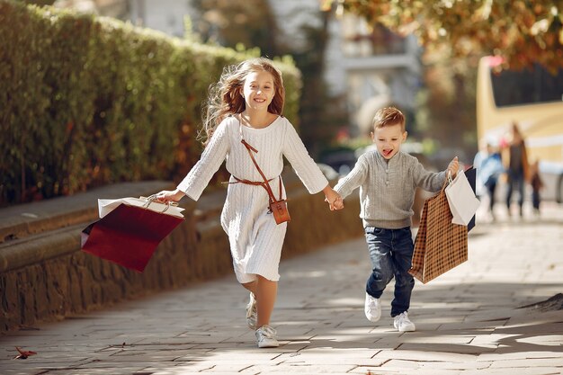 Mignons petits enfants avec un sac dans une ville