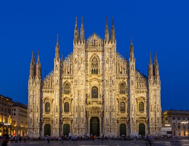 Milan, italie - 28 avril 2018 : les touristes pendant l'heure bleue prennent des photos sur la place du duomo, le principal point de repère de la ville.