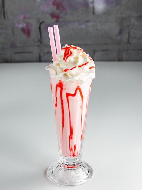 Milk-shake aux fraises avec crème fouettée et sirop de fraise