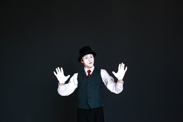 Photo gratuite un mime confiant tient ses paumes sur un mur invisible